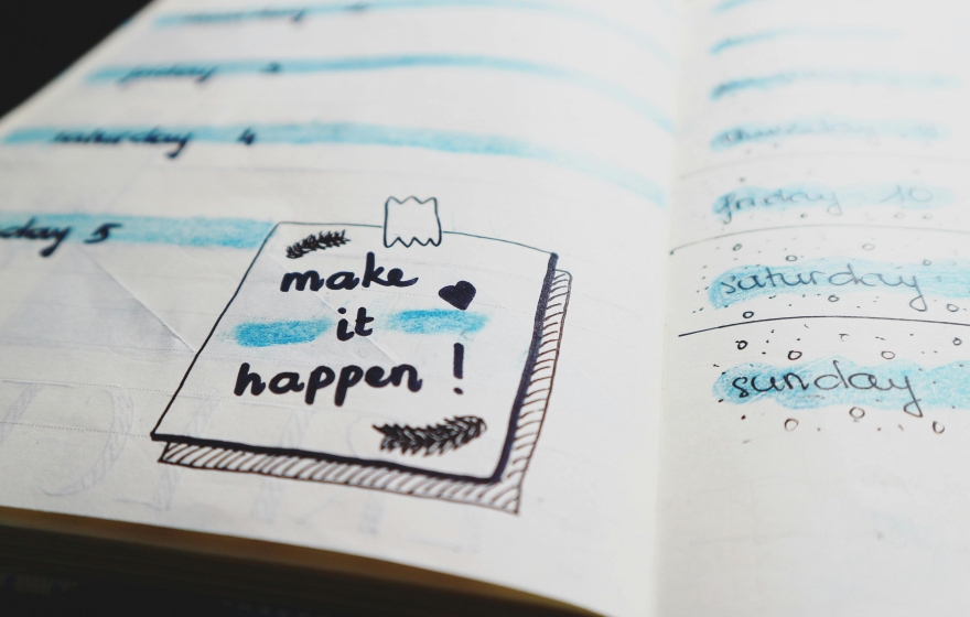 planning notebook with a sticky note saying Make it Happen!