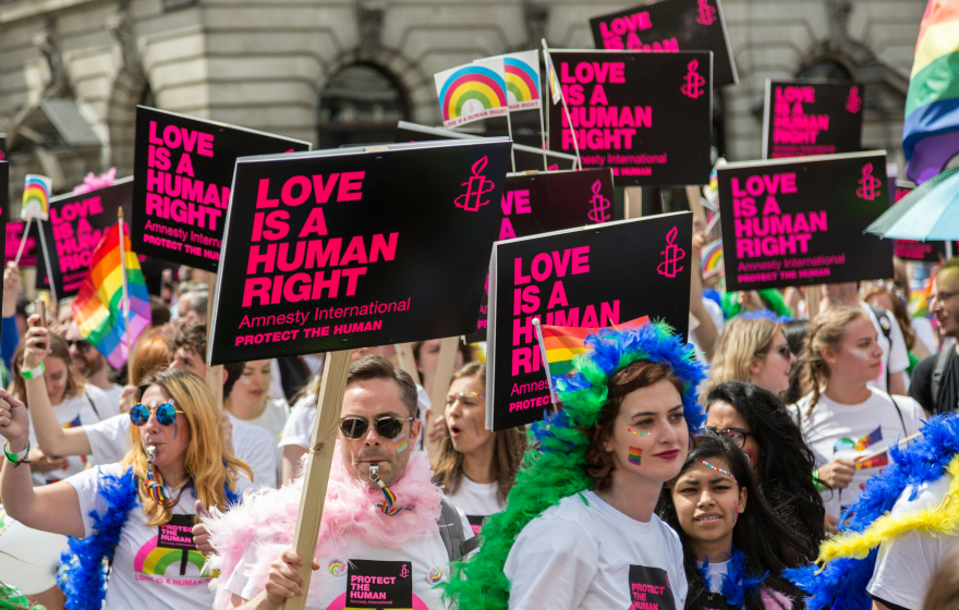 LGBTQ march people with signs saying Love is Love