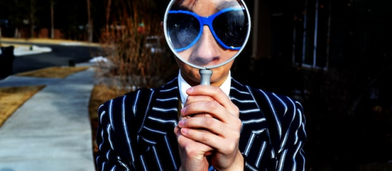Person gazing through a magnifying glass. 