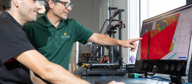 Researchers pointing at a computer screen